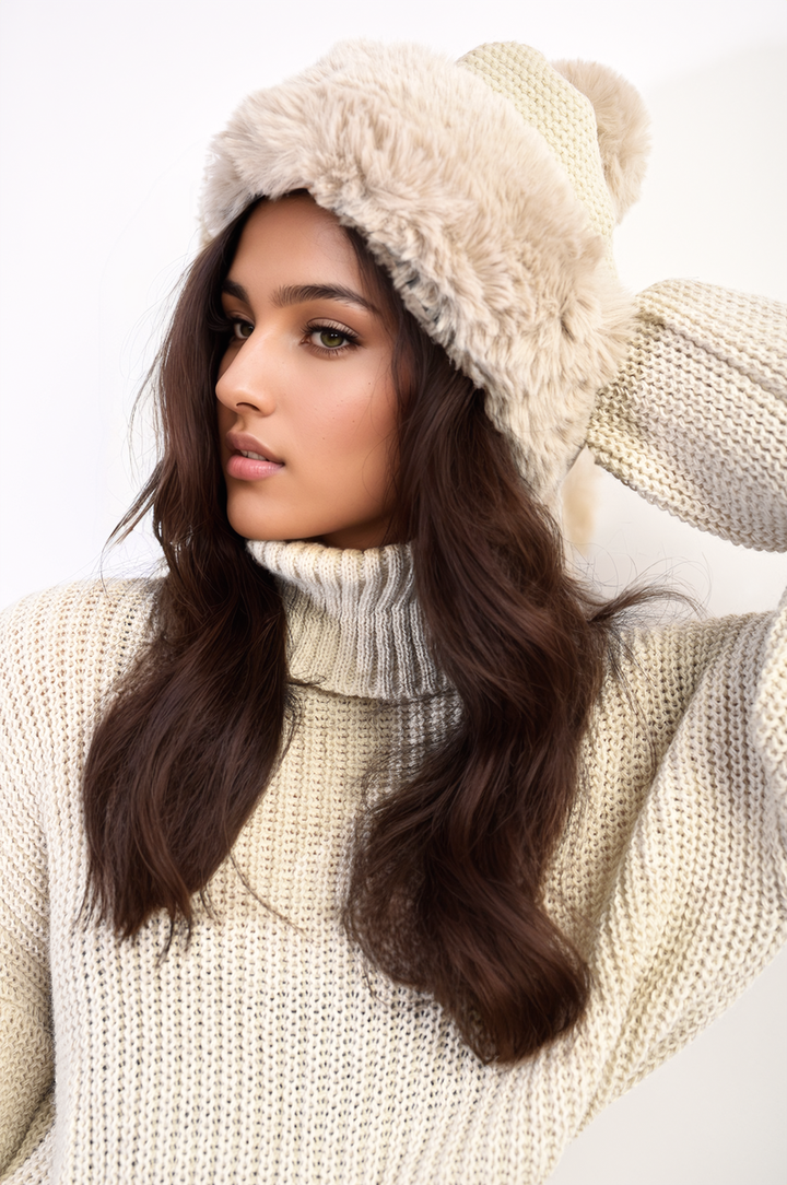 Woman wearing the Carly Faux Fur Knitted Winter Hat, featuring a cozy knitted design with a playful pom-pom, perfect for stylish warmth in winter.