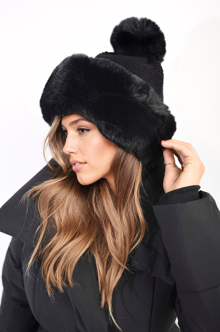 Woman wearing the Carly Faux Fur Knitted Winter Hat, featuring a plush faux fur lining and playful pom-pom, showcasing its stylish winter design.