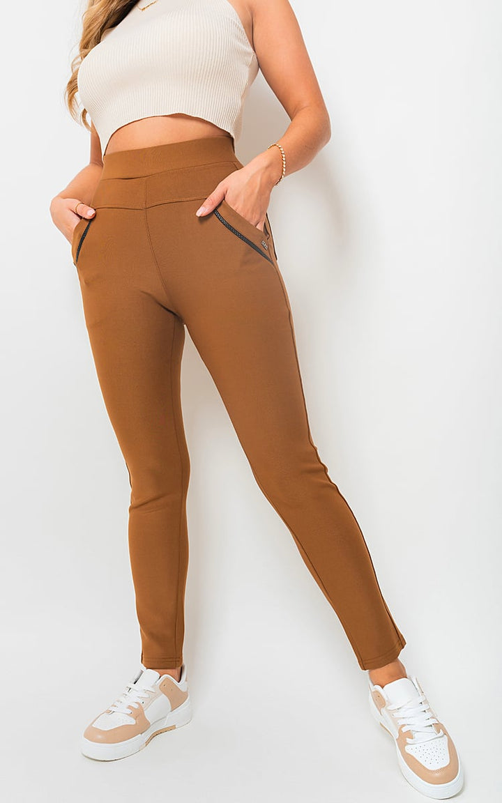 A woman models the High Waist Double Band Pocket Leggings, highlighting the leggings’ high waist and functional side pockets.