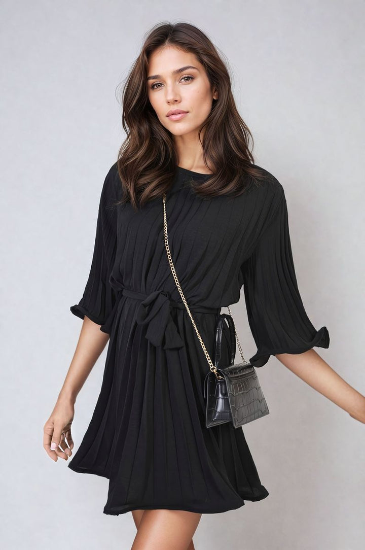 Pleated Tie Waist Mini Dress on model, showcasing its elegant pleating and tie waist design for a flattering silhouette. Perfect for stylish holiday wear.