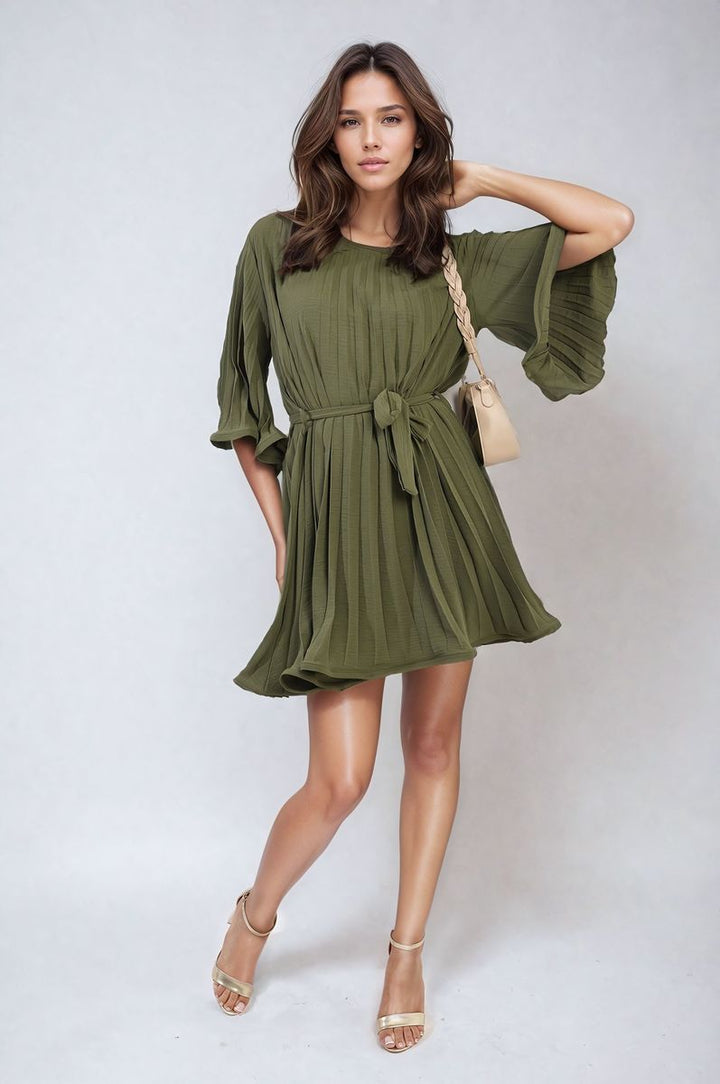 Pleated Tie Waist Mini Dress modeled with gold sandals, showcasing elegant pleating and a flattering silhouette. Perfect for any occasion.