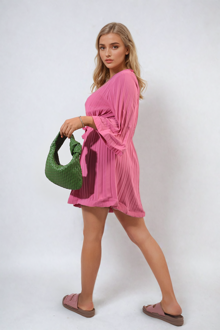 Pleated Tie Waist Mini Dress worn by a woman holding a green purse, showcasing its elegant fit and pleated design, ideal for holiday occasions.