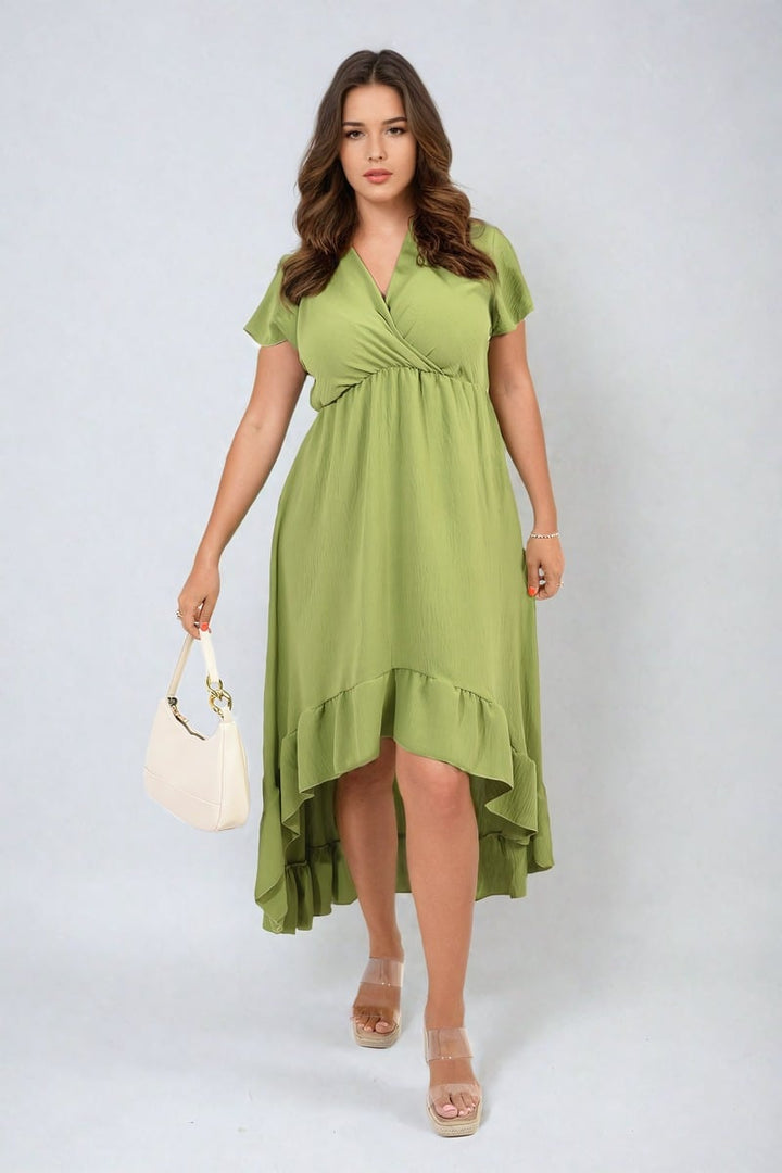 Woman modeling the Catalina High Low Ruffle Hem Maxi Dress, featuring a flowing ruffled hem, complemented by sandals and a purse, embodying elegance and style.