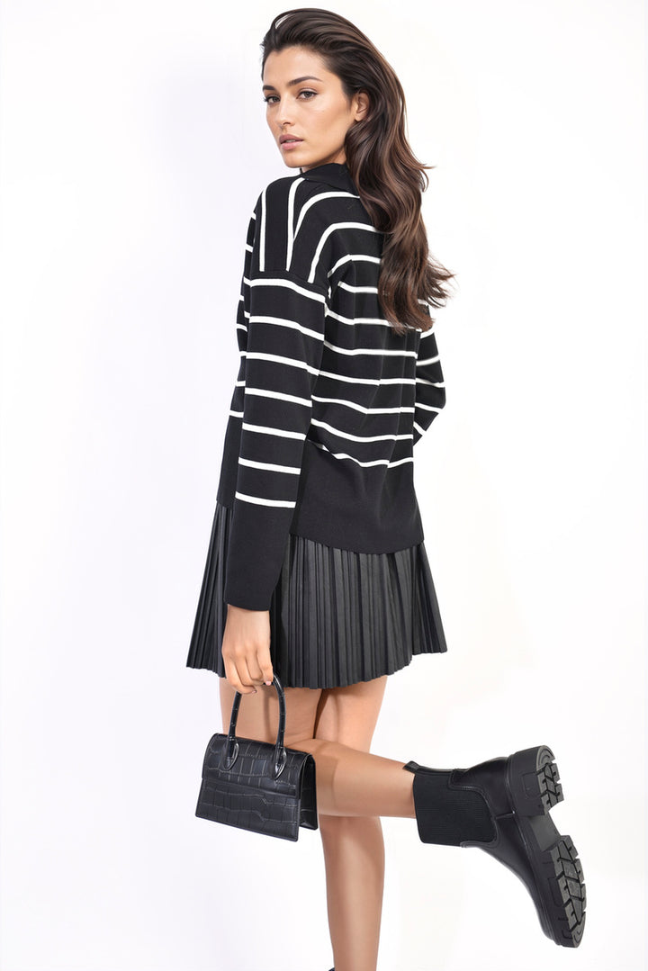 Woman wearing Cecelia Striped Knitted Jumper with black skirt and boots, holding a black purse.