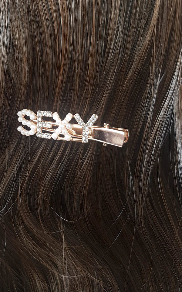 Sexy Slogan Diamante and Pearl Hair Clip embellished with gemstones and pearls, featuring 'SEXY' slogan. Perfect for adding a stylish touch to any look.