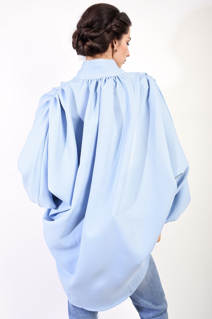 Oversized High Neck Shirt: A woman models a stylish, relaxed-fit blouse, highlighting its versatile design and comfortable fabric for casual or sophisticated looks.