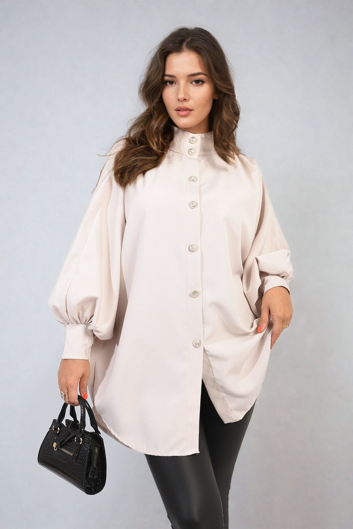 Woman holding a black purse and wearing an oversized high-neck shirt, highlighting its relaxed fit and stylish design. Perfect for casual or sophisticated looks.