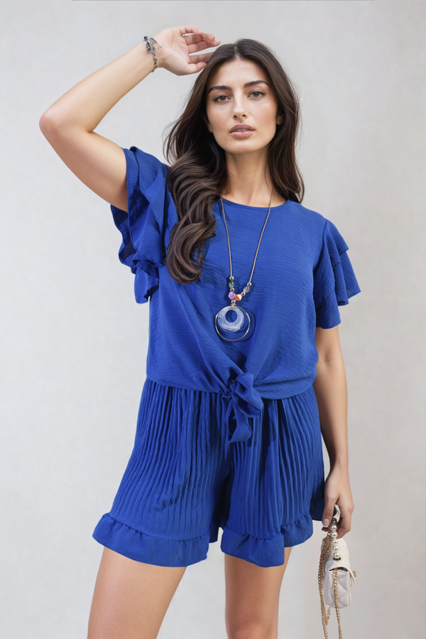 Woman wearing the Cynthia Layered Ruffle Short Sleeve Tie Front Top, showcasing its playful ruffles and stylish tie front detail.