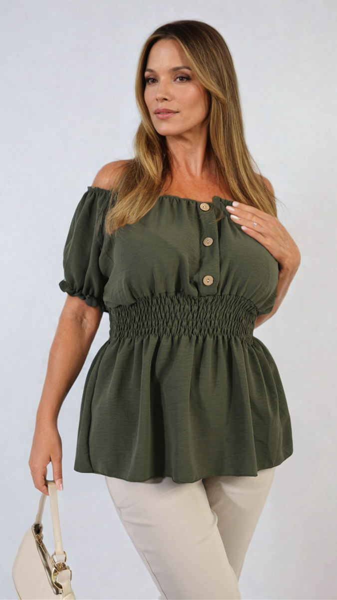 Woman in a green dress showcasing the Daniela Button Front Cinched Waist Top, highlighting its figure-flattering design with stylish button details and adjustable cinched waist.