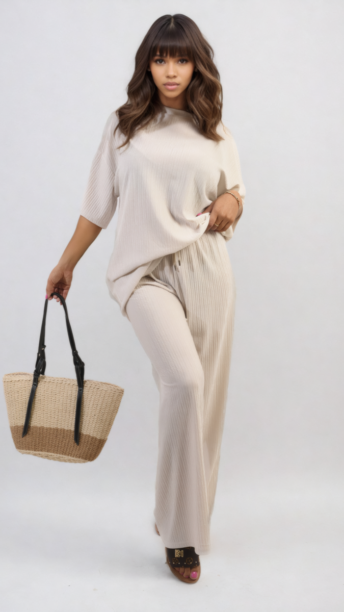 Woman wearing Ribbed Oversized Top and Drawstring Wide Leg Trouser Co-ord Set, holding a straw bag, showcasing a stylish, comfortable look.