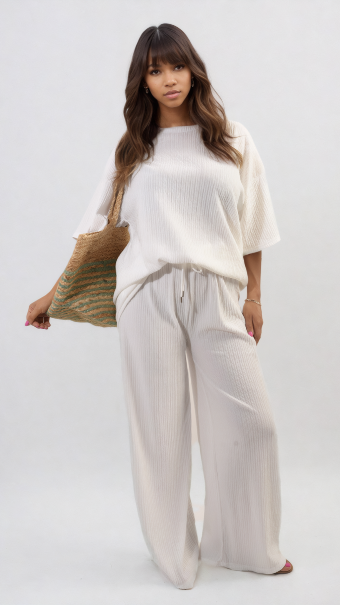 Woman in white holding a Ribbed Oversized Top and Drawstring Wide Leg Trouser Co-ord Set, showcasing its relaxed and stylish design.