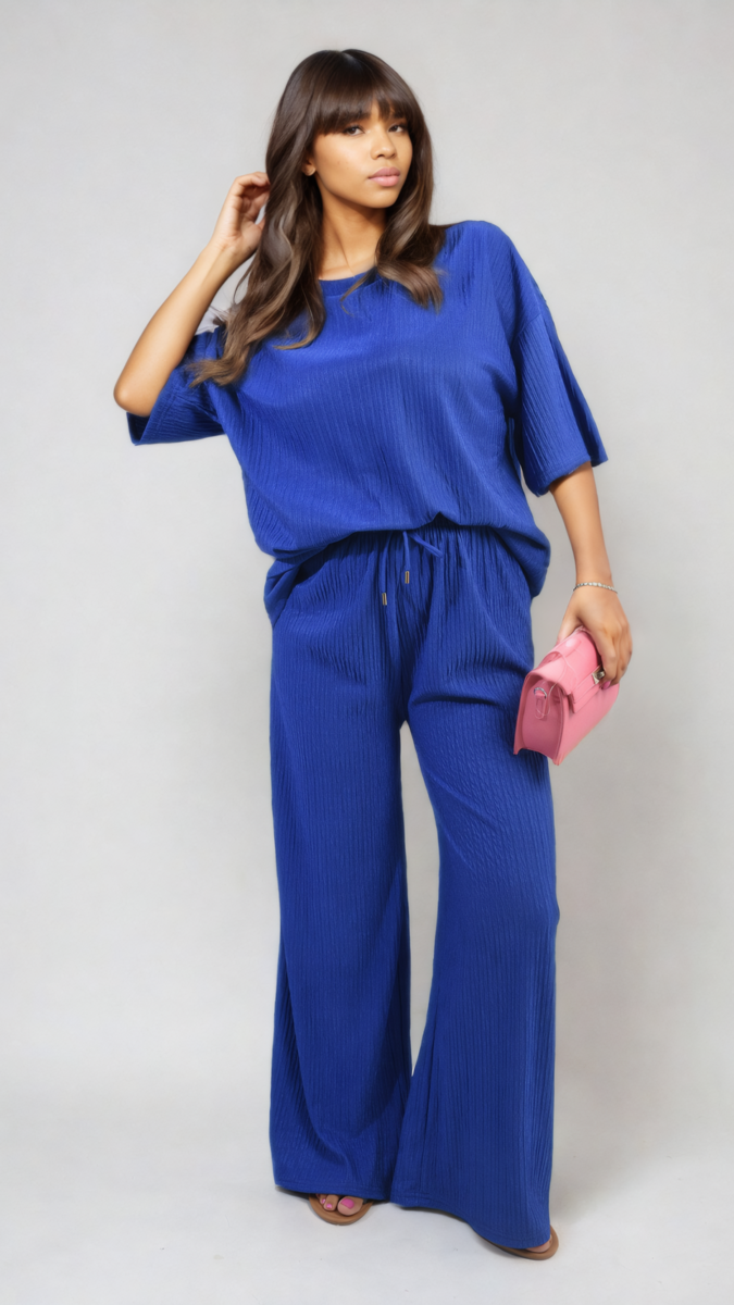 Woman in Ribbed Oversized Top and Drawstring Wide Leg Trouser Co-ord Set holding a pink purse, showcasing comfy chic style.