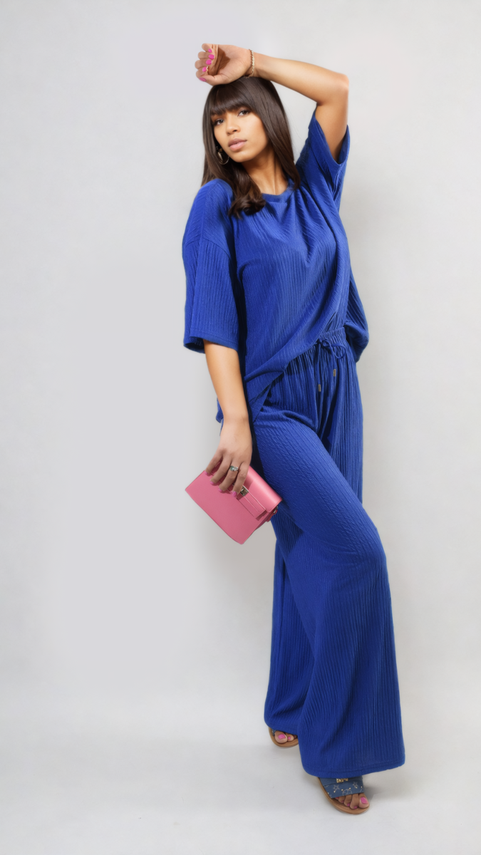 Woman in Ribbed Oversized Top and Drawstring Wide Leg Trouser Co-ord Set holding a pink purse, showcasing chic and cozy fashion.