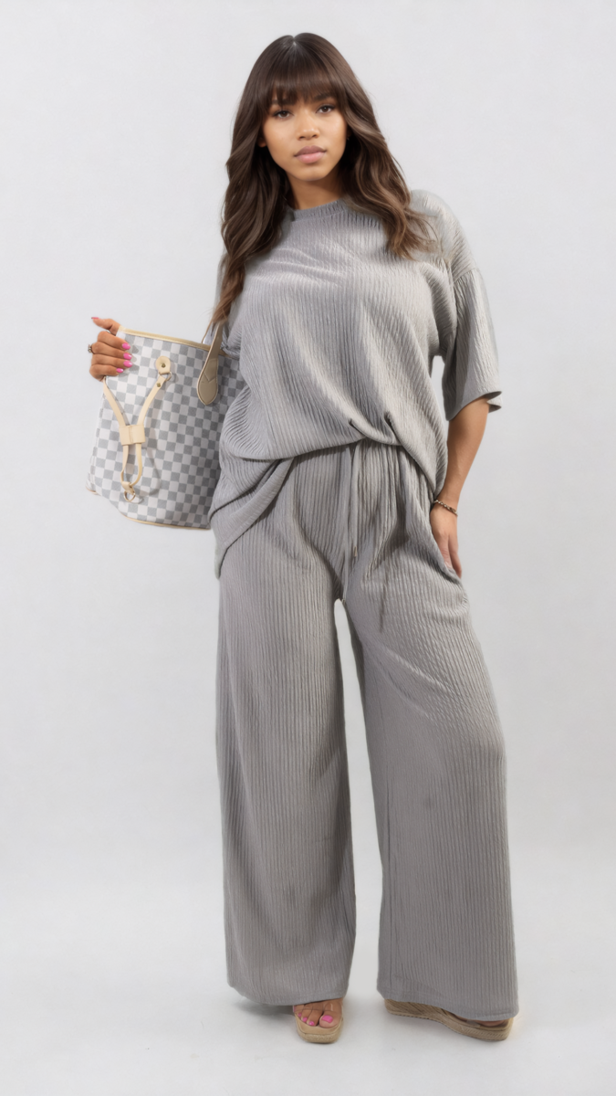 Woman wearing the Ribbed Oversized Top and Drawstring Wide Leg Trouser Co-ord Set, holding a purse, showcasing a stylish and comfortable look.