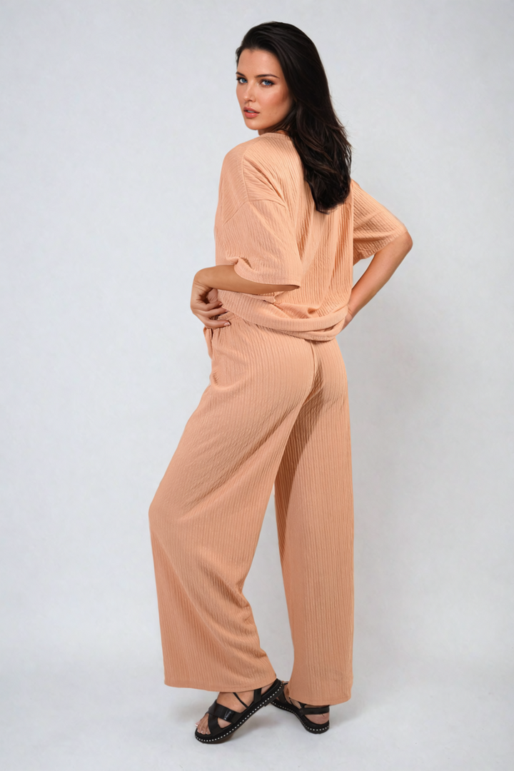 Woman models Ribbed Oversized Top and Drawstring Wide Leg Trouser Co-ord Set, showcasing comfortable and stylish loungewear from Holiday Clothes UK.