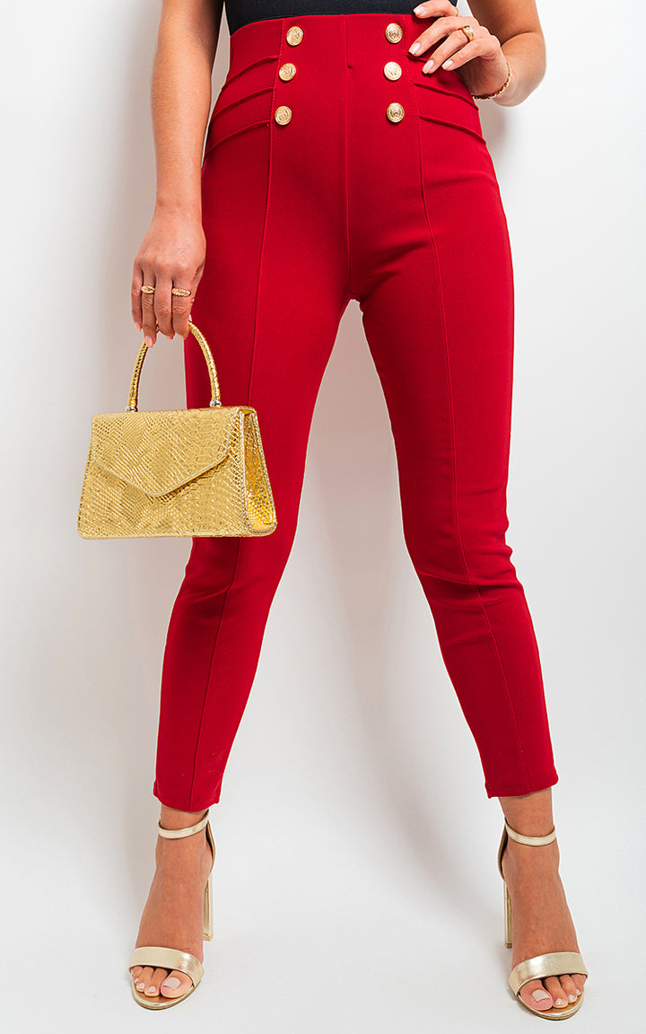 Woman wearing High Waisted Button Front Leggings, holding a gold purse. The leggings feature a stylish button front detail, emphasizing their fashionable design.