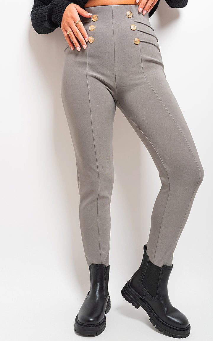 Woman wearing High Waisted Button Front Leggings with black boots, showcasing the leggings' flattering fit and sophisticated button detail.