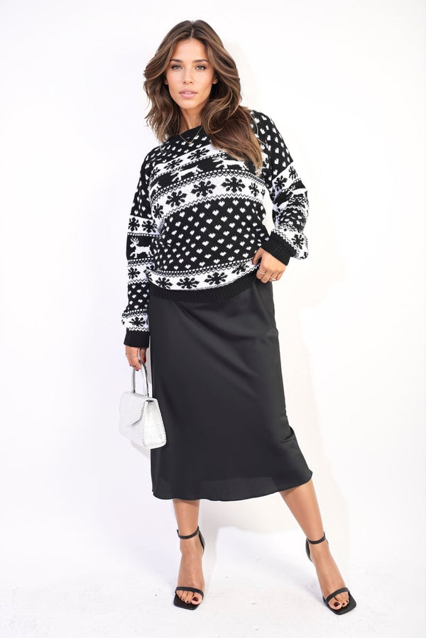 Woman wearing an Oversized Christmas Jumper with snowflake and reindeer design, paired with a black skirt, showcasing festive fashion.