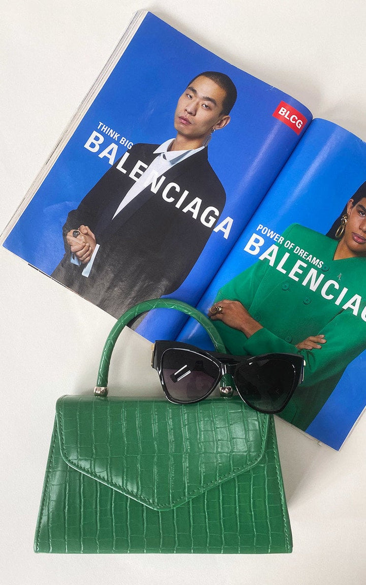 Croc Print Handbag with faux leather, handheld handle, and chain strap, displayed with sunglasses on a magazine.