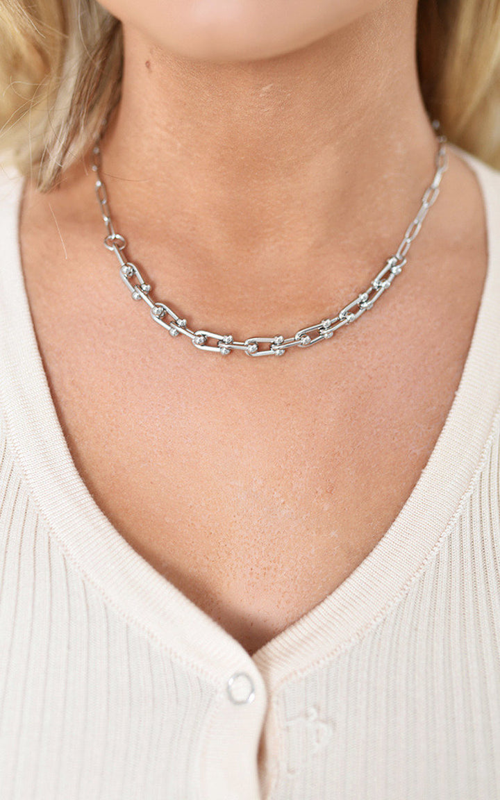 Woman wearing the Paper Clip Chain Necklace, a sophisticated fashion accessory from Holiday Clothes UK, elegantly styled to enhance any outfit with glamour.