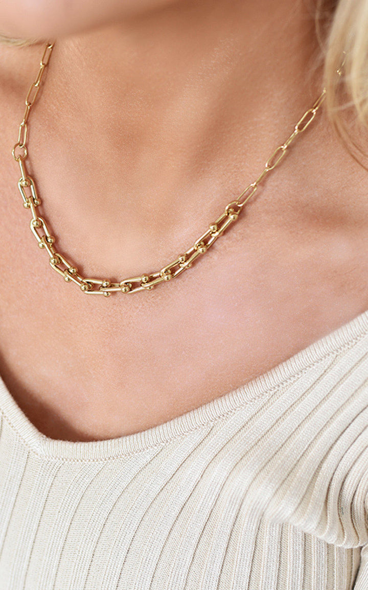 Woman wearing the Paper Clip Chain Necklace, showcasing its elegant design and sophisticated style, perfect for adding glamour to any outfit.