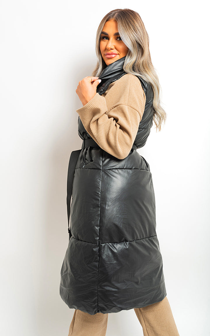 Woman showcasing the Dorothy Belted Long Puffer Gilet, a stylish, waist-accentuating outerwear ideal for warmth and sophistication on chilly days.