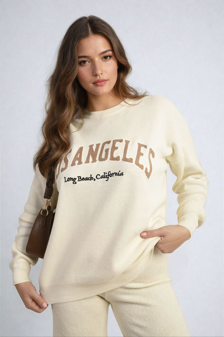 Woman wearing Los Angeles Graphic Long Sleeve Knitted Jumper, showcasing its cozy knitted fabric and trendy design, ideal for chic, comfortable styling.