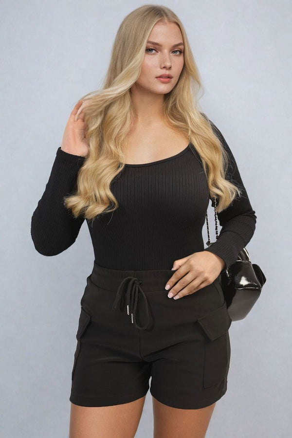 Woman wearing black shirt and shorts, holding a black purse. Showcasing Elastic Waist Drawstring Pocket Detail Shorts for stylish and comfortable wear.