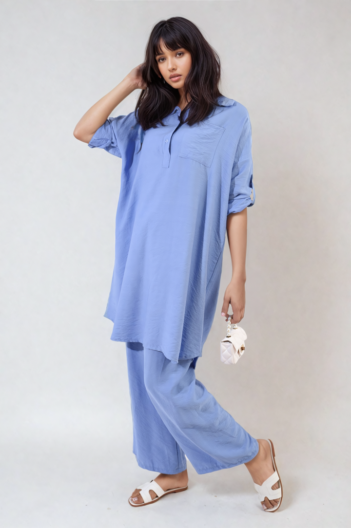 Woman wearing the Dulce Oversized Button Front Shirt & Wide Leg Pants Co-ord Set, holding a pearl necklace, featuring a casual and comfortable design.