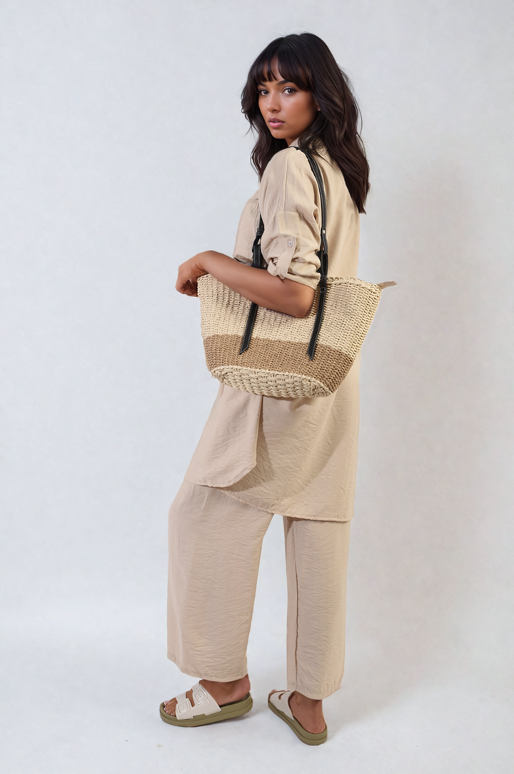 Woman wearing the Oversized Button Front Shirt & Wide Leg Pants Co-ord Set, holding a woven bag, showcasing its relaxed, stylish design perfect for casual occasions.