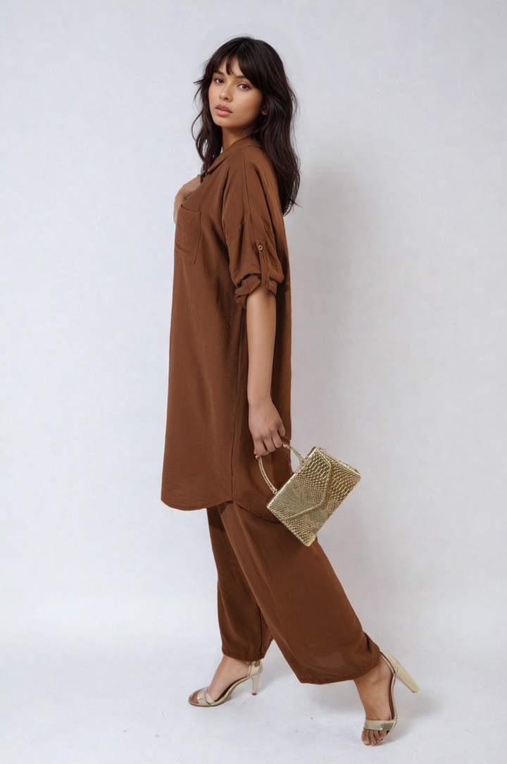 Woman modeling the Oversized Button Front Shirt & Wide Leg Pants Co-ord Set, holding a gold purse and wearing high heels, showcasing a stylish, relaxed look.