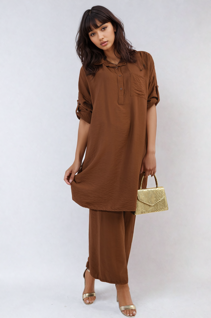 Woman in Oversized Button Front Shirt & Wide Leg Pants Co-ord Set, holding a gold purse, capturing a relaxed, stylish look.