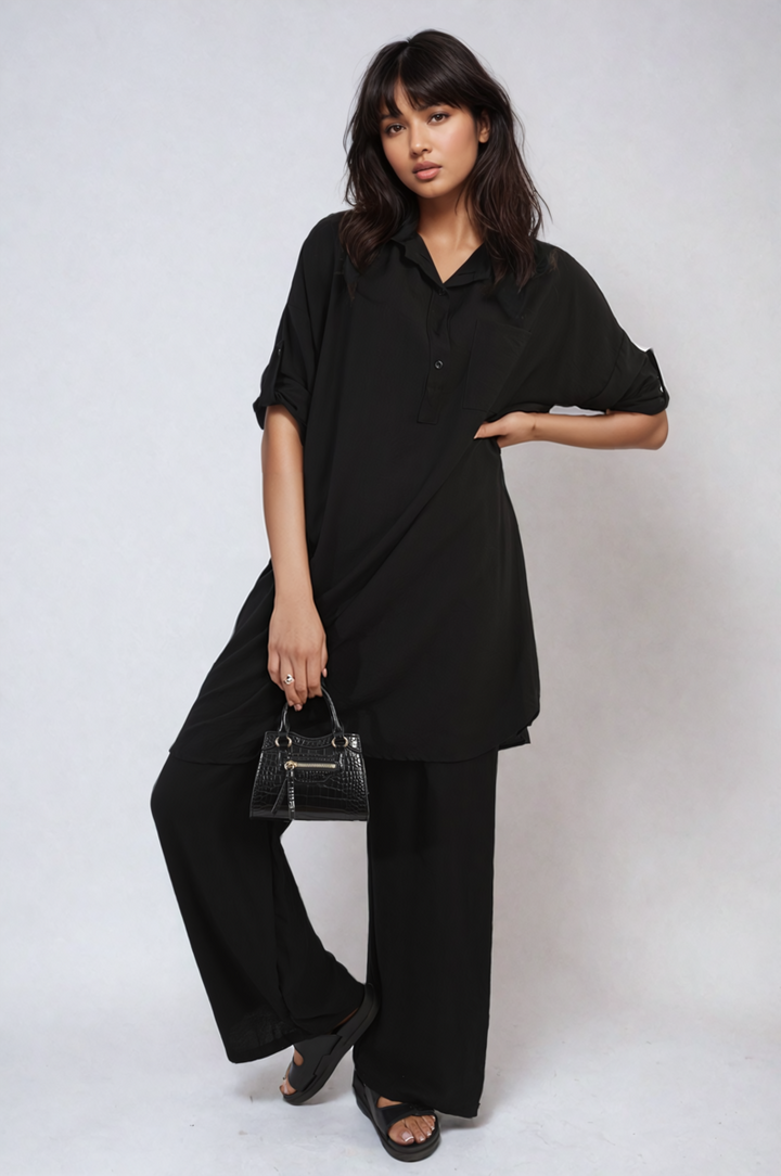 Woman wearing Oversized Button Front Shirt & Wide Leg Pants Co-ord Set, holding a black purse, showcasing a stylish and comfortable outfit from Holiday-clothes.co.uk.