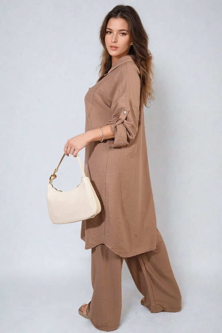 Woman wearing Oversized Button Front Shirt & Wide Leg Pants Co-ord Set, holding a white purse, ideal for relaxed, stylish holiday wear.