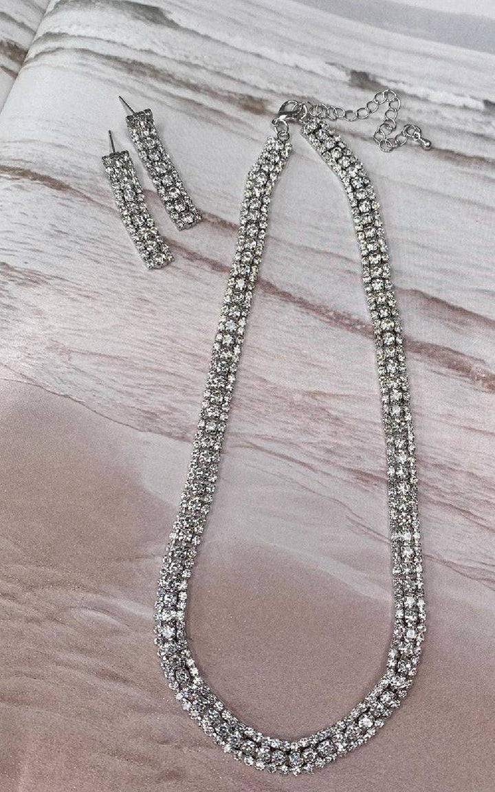 Diamante Necklace and Earrings Set featuring cubic zirconia stones on a marble surface, perfect for adding elegance to any outfit or special occasion.