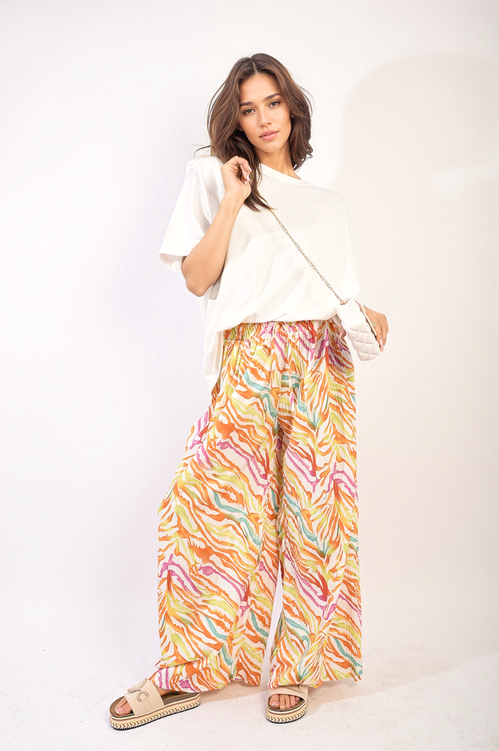 Woman wearing Pleated Wide Leg and Elastic Waist Trousers, showcasing a sophisticated design ideal for various occasions, paired with a white shirt and purse.