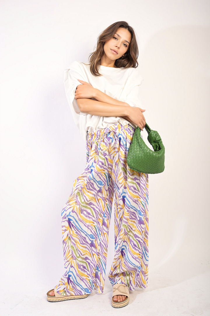 Woman posing with Pleated Wide Leg and Elastic Waist Trousers, showcasing their elegant pleated design and comfortable fit, ideal for various occasions.