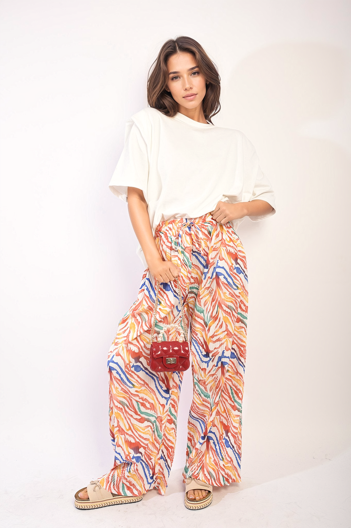 Woman holding Pleated Wide Leg and Elastic Waist Trousers, showcasing their elegant, wide-leg design and comfortable elastic waistband, perfect for versatile styling.