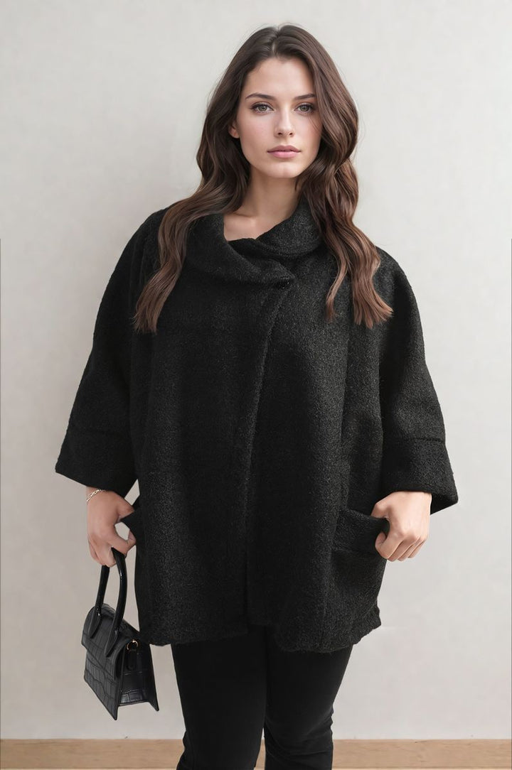 Woman wearing the Elle Cowl Neck Oversized Cape Jacket, showcasing its cozy fit and stylish cape design, ideal for layering on chilly days.