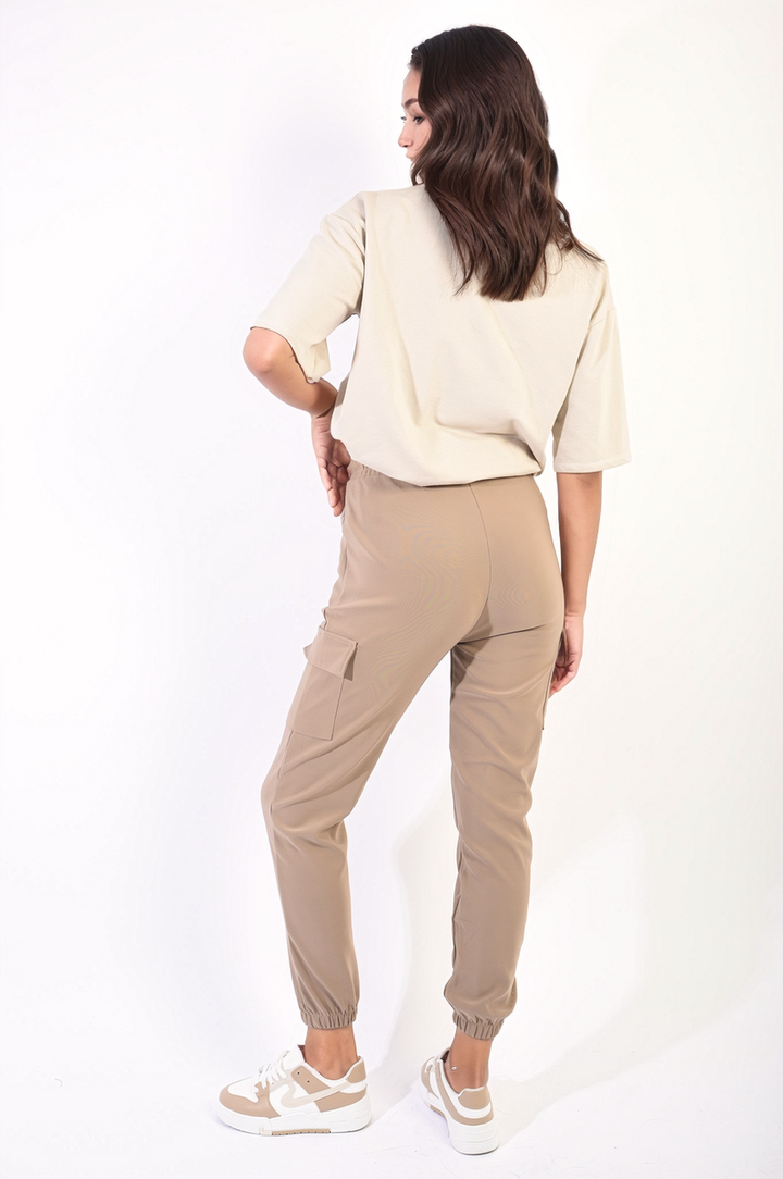 Woman wearing Cargo Pocket Trouser with Drawstring, featuring utility pockets and adjustable waist, ideal for stylish and comfortable everyday or holiday wear.