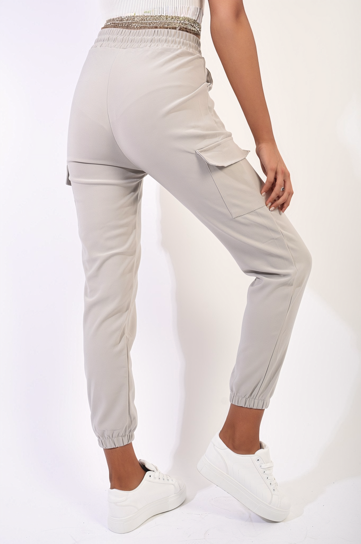 Woman wearing Cargo Pocket Trouser with Drawstring, showcasing adjustable waist and multiple cargo pockets for style and functionality in a casual setting.