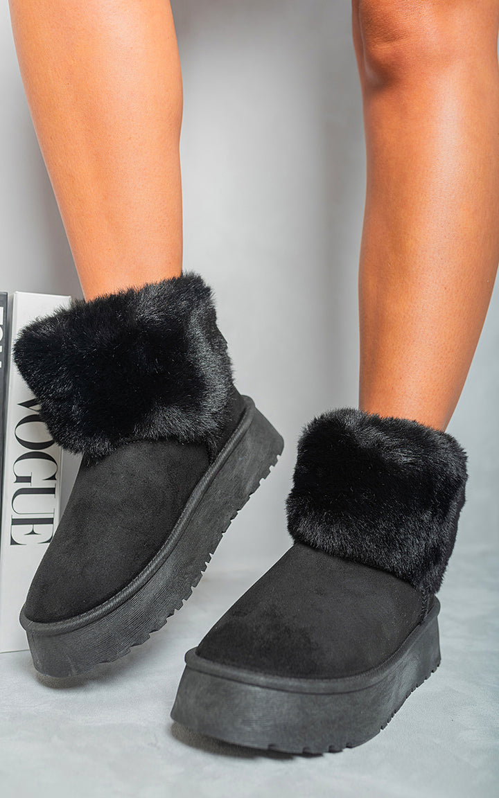 Fuzzy Cuff Slip On Snow Boots with faux fur, ideal for winter adventures, offering warmth and stylish comfort, showcased in a cozy, indoor setting.