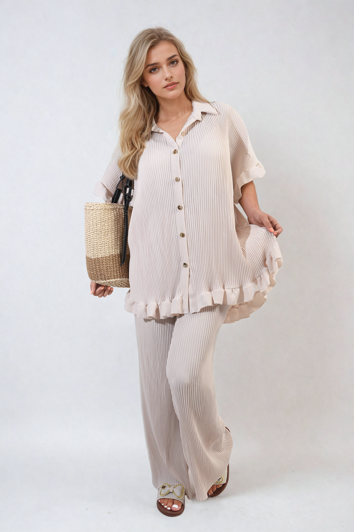 Woman wearing Button Pleated Frill Ruffle Top and Wide Leg Trouser Co-ord Set, holding a straw bag, showcasing elegant and sophisticated design.