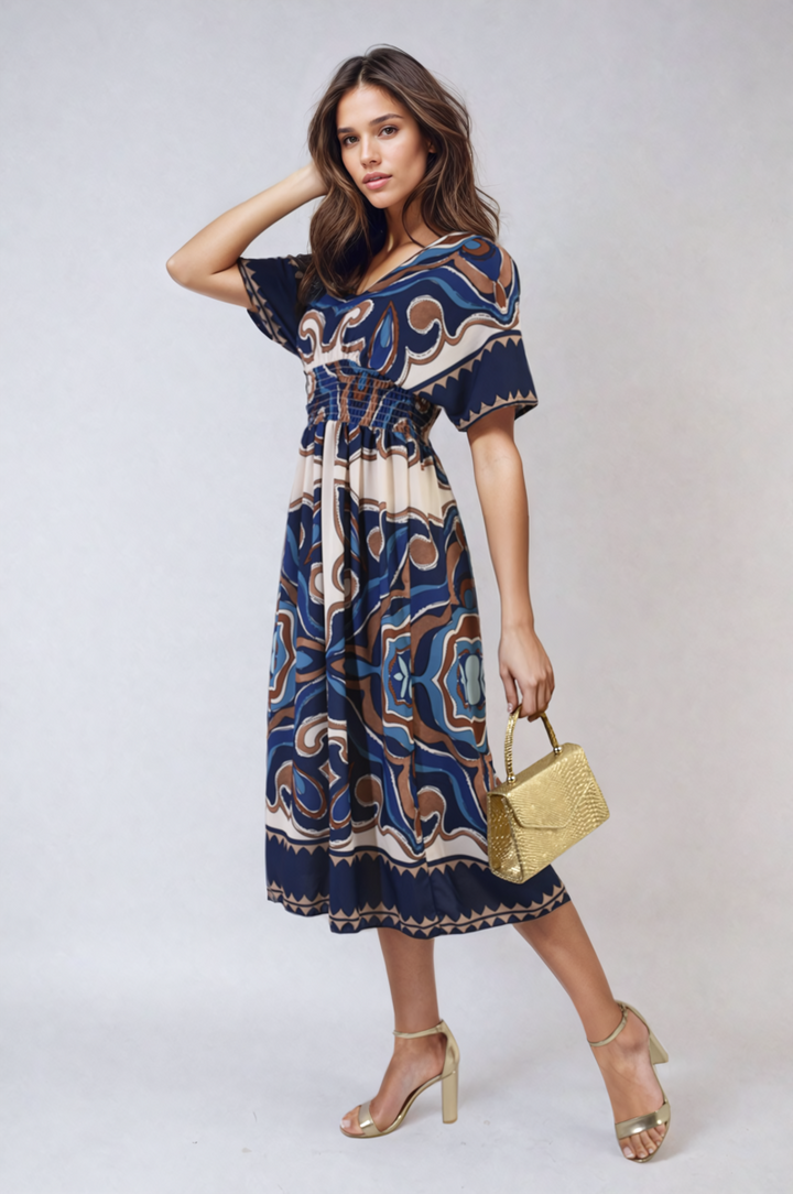 Woman in Ruched Printed V-Neck Short Sleeve Midi Dress holding a gold purse, showcasing a stylish casual look for holiday occasions.