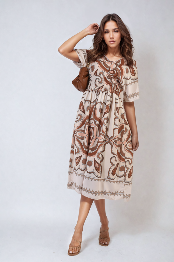 Woman wearing Estella Ruched Printed V-Neck Short Sleeve Midi Dress, showcasing its flattering ruched design and chic printed pattern, perfect for casual occasions.