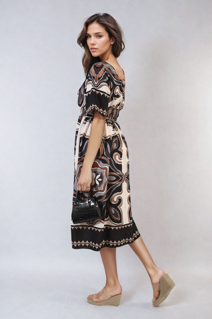 Ruched Printed V-Neck Short Sleeve Midi Dress worn by a woman holding a black purse, showcasing its chic ruched design and printed pattern.