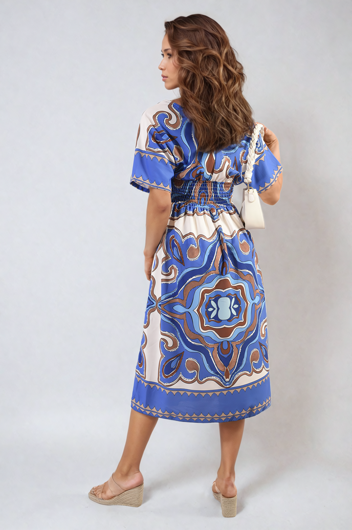 Ruched Printed V-Neck Short Sleeve Midi Dress modeled by a woman, showcasing its chic printed pattern and flattering ruched design, suitable for casual occasions.