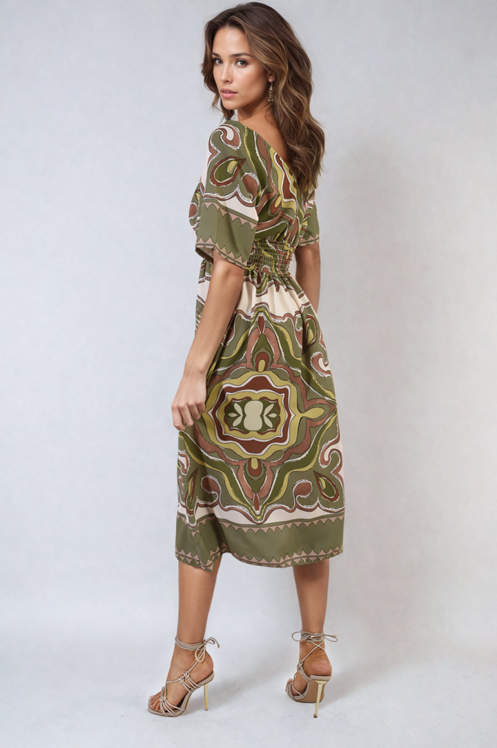 Woman modeling the Ruched Printed V-Neck Short Sleeve Midi Dress, showcasing its chic printed pattern and flattering ruched design, ideal for casual occasions.