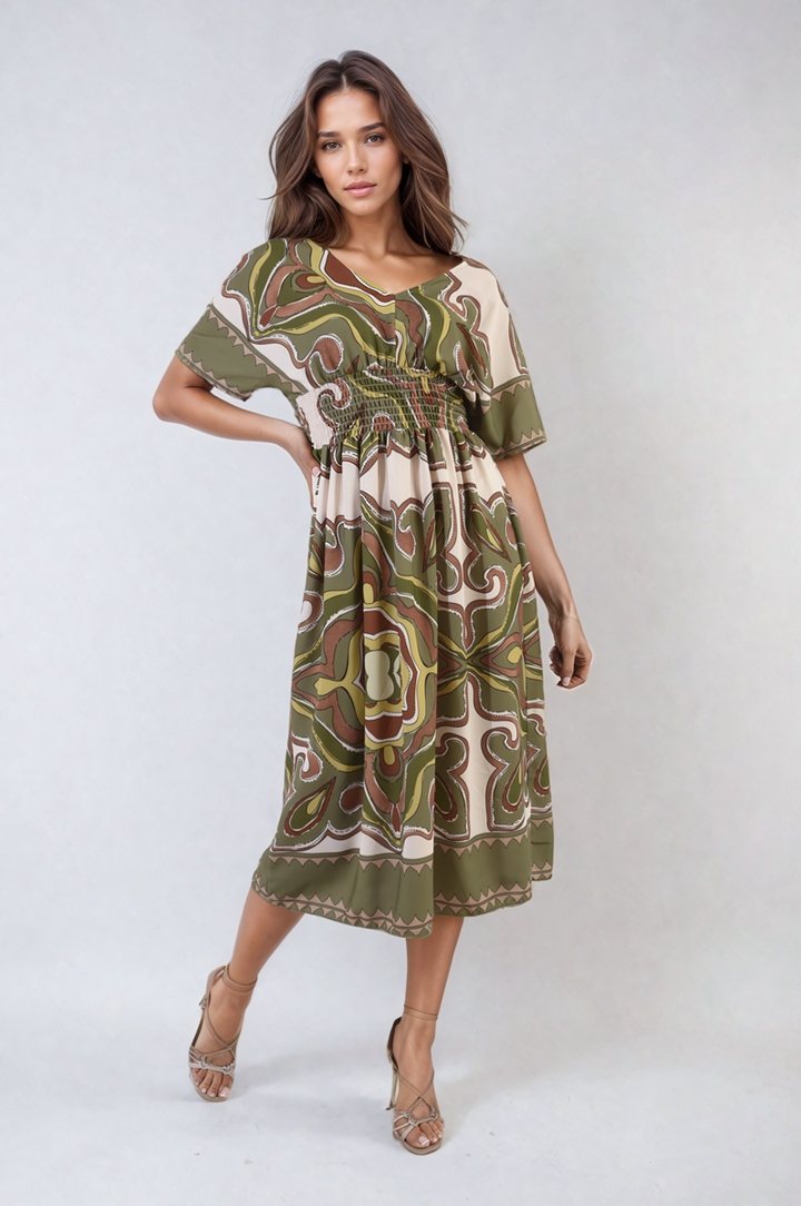 Woman wearing the Ruched Printed V-Neck Short Sleeve Midi Dress, showcasing its flattering ruched design and chic printed pattern, ideal for casual occasions.