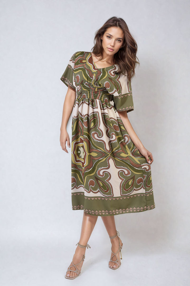 Woman wearing Estella Ruched Printed V-Neck Short Sleeve Midi Dress, showcasing its chic ruched design and stylish pattern, ideal for casual occasions.